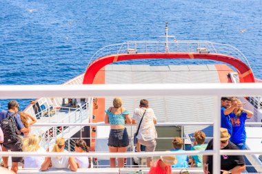 İnsanlar teknede, denize bakıyorlar. İnsanlar manzaranın ve birbirlerinin arkadaşlığının tadını çıkarırken, manzara rahat ve sakin. 5 Ağustos 2024 Keramoti 'den Yunanistan' a feribot