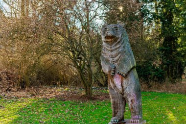 Huzur parkında ağaçlarla çevrili dev ayı heykeli. 17 Mart 2025, Konopiste Şatosu, Çek Cumhuriyeti.