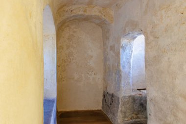 Tarihi binada kemerli kapıları ve dokulu duvarları olan taştan bir koridor. 18 Mart 2025, Madalyon, Çek Cumhuriyeti.