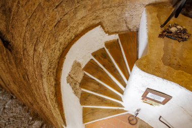 Eski taş binada ahşap merdivenleri ve beyaz duvarları olan taşralı spiral merdivenler. 18 Mart 2025, Madalyon, Çek Cumhuriyeti.