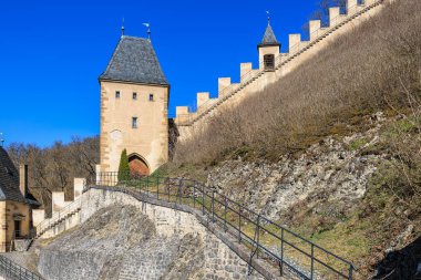 Ortaçağ taş kale duvarları ve mavi gökyüzüne karşı kule.