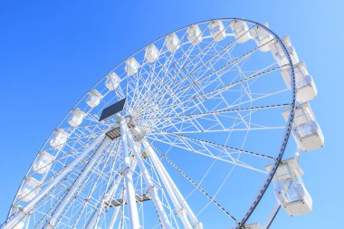 Mavi gökyüzüne karşı dev beyaz dönme dolap..