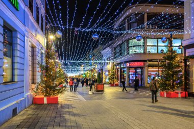 Noel ışıkları ve insanların yürüdüğü işlek bir cadde. Manzara şenlikli ve canlı. 13 Aralık 2024 Brasov Romanya