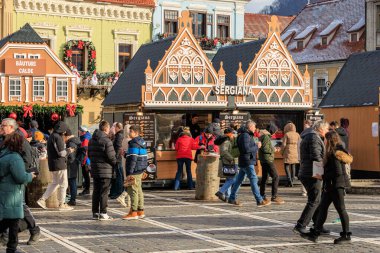 Bir sürü insanın dolaştığı işlek bir cadde. Bir binanın önünde duran birkaç kişi var, kış ya da Noel panayırı. 14 Aralık 2024 Brasov Romanya