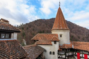 Kırmızı çatılı, beyaz çatılı, Drakula kaleli bir bina. 16 Aralık 2024 Bran Romanya.