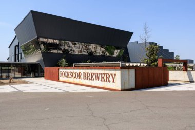 Geometrik mimarisi ve yansıtıcı cam cepheli modern bira fabrikası. 25 Nisan 2025 Gindesti Moldova.