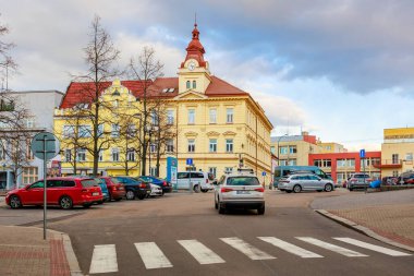 Bulutlu bir günde klasik mimari ve trafik olan tarihi Avrupa şehir meydanı. 17 Mart 2025, Benesov, Çek Cumhuriyeti.