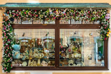 Çiçek aksanlı klasik oyuncak ve dekor mağazası önü. 20 Mart 2025, Cesky Krumlov, Çek.