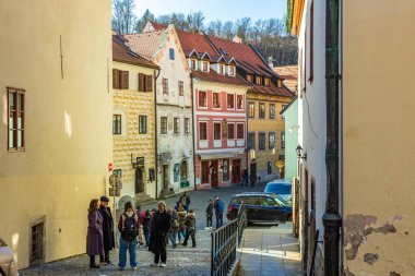 Farklı turistlerin tarihi kent mimarisini araştırdığı büyüleyici bir sokak manzarası. 20 Mart 2025, Cesky Krumlov, Çek.