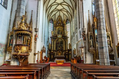 Avrupa 'nın tarihi katedralinin içini özenle hazırlanmış sunaklar ve sıralarla süsleyin. 20 Mart 2025, Cesky Krumlov, Çek.