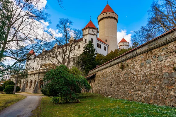 Yeşillik ve taş duvarların arasında kırmızı kuleleri olan ortaçağ kalesi..