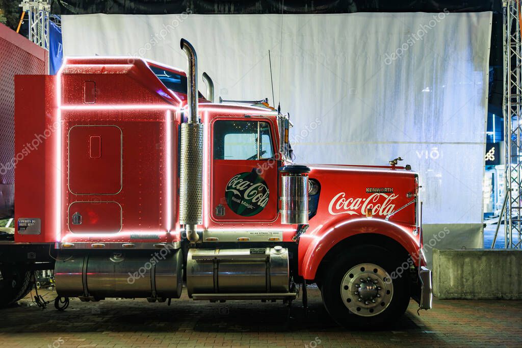 Illuminated red coca-cola truck display with neon lights at night event. December 27, 2024 Balti Moldova.