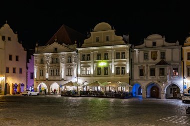 Czech Cumhuriyeti 'nde aydınlatılmış binalarla tarihi kasaba meydanının gece manzarası. 20 Mart 2025, Cesky Krumlov, Çek.