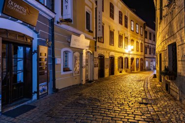 Tarihi binaları ve kaldırım taşı yolu olan büyüleyici bir gece manzarası. 20 Mart 2025, Cesky Krumlov, Çek.