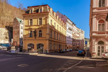 Avrupa 'nın tarihi mimarisi ile güneşli bir sokak sahnesi. 18 Mart 2025, Karlovy Vary, Çek Cumhuriyeti.