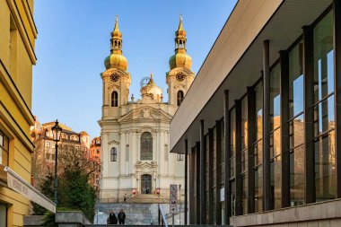 Prag 'daki barok kilisesi mimari kontrastı ve mavi gökyüzü. 18 Mart 2025, Karlovy Vary, Çek Cumhuriyeti.