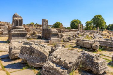 Eski bir binanın kalıntıları bir tarlaya saçıldı. Gökyüzü açık ve mavidir, ve güneş parlıyor. Yunanistan 'ın antik Filippi kentinin kalıntıları