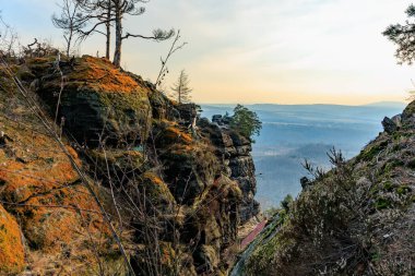Sisli ormanın üzerinde kayalık kanyon manzarasından gün doğumu.