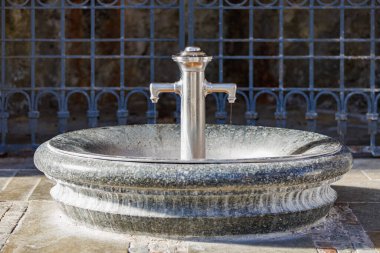 Tarihi ortamda çift ağızlı zarif taş su çeşmesi..