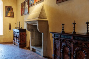 Taş şömineli ve ahşap dolaplı tarihi ortaçağ odası. 19 Mart 2025, Karlstejn, Çek Cumhuriyeti.