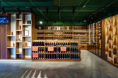 Modern içki dükkanının içinde çeşitli şaraplar ve ahşap raflarda ruh seçimleri var. 1 Mart 2023 Balti Moldova.