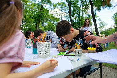 Çocuklar bir park ortamında açık havada sanat faaliyetinde bulunuyorlar. 31 Mayıs 2024 Balti Moldova.
