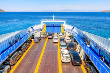 Bir tekne güvertede park edilmiş birçok arabalı bir rıhtıma yanaştı. Olay yeri sakin ve sakin bir yer. 7 Ağustos 2024 Thassos 'tan Keramoti Yunanistan feribotu