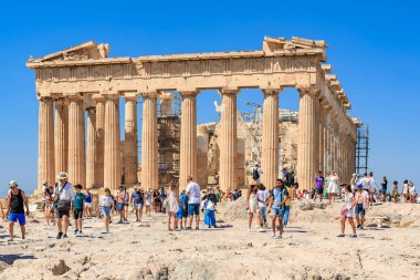 Büyük bir grup insan sütunlarla büyük bir binanın etrafında yürüyor. Manzara hareketli ve hareketli, her yaştan insan birlikte vakit geçiriyor. 9 Ağustos 2024 Atina Yunanistan