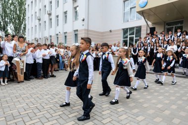 Okul seremonisinde resmi üniformalı genç öğrenciler birlikte yürüyorlar. 2 Eylül 2024 Balti Moldova.