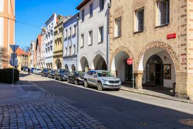Güneşli bir günde renkli binaları ve kemerli cepheleri olan tarihi Avrupa caddesi. 21 Mart 2025, Ceske Budejovice, Çek.