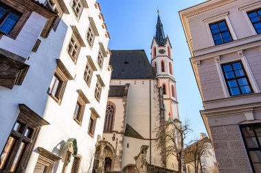 Güneşli bir günde tarihi Avrupa mimari kulesi ve çevresindeki binalar. 20 Mart 2025, Cesky Krumlov, Çek.
