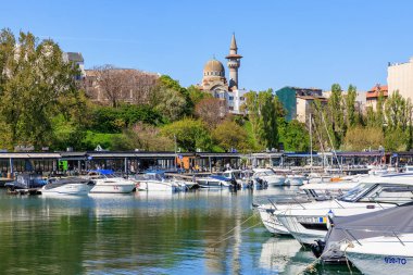 Açık bir günde Belgrad 'da tekne ve camii olan bir marina. 3 Mayıs 2025 Romanya.