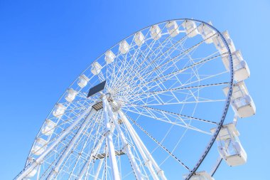 Güneşli bir günde berrak mavi gökyüzüne karşı görkemli dönme dolap..