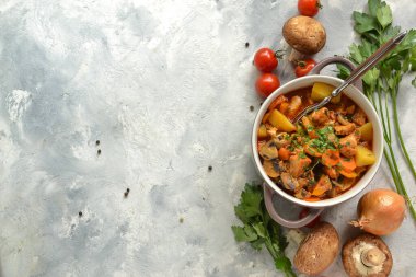 Tavuk, patates, soğan, mantar, domates, havuç ve maydanozlu güveç. Sebze yahnisi.