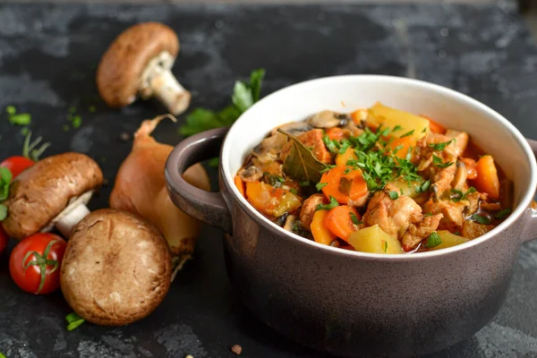 Stew with chicken, potatoes, onions, mushrooms, tomatoes and carrots, and parsley. Vegetable stew