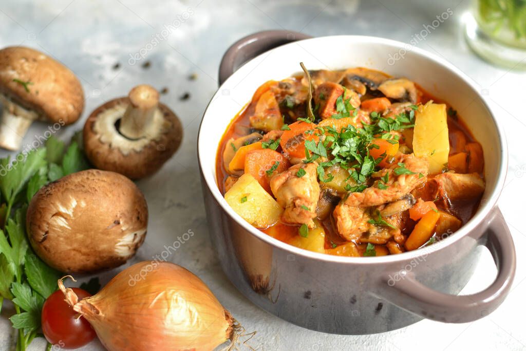 Stew with chicken, potatoes, onions, mushrooms, tomatoes and carrots, and parsley. Vegetable stew