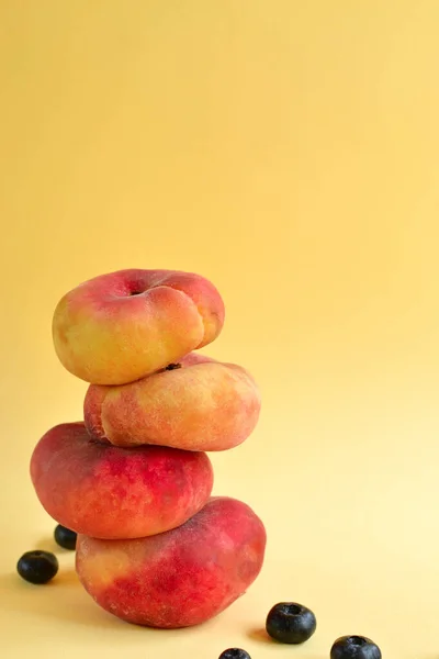 Peach on a white background. Juicy ripe peach and blueberry. Creative minimalistic food concept.