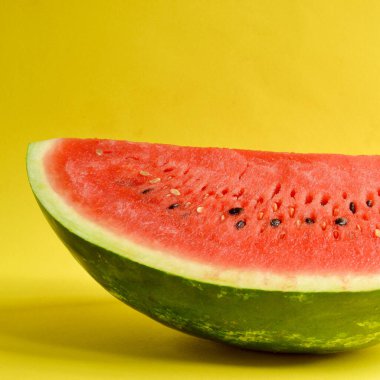 Sarı arka planda izole edilmiş taze kesilmiş karpuz. Olgun kırmızı karpuz. Asgari yaratıcı konsept. Mesaj için yer. Parlak, sağlıklı yaz yemekleri. Yarım karpuz.