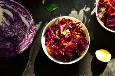 Kırmızı lahana salatası, dolmalık biber ve havuç. Karanlık arka plan. Sağlıklı, parlak yiyecekler.