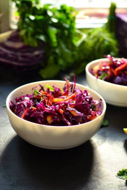 Kırmızı lahana salatası, dolmalık biber ve havuç. Karanlık arka plan. Sağlıklı, parlak yiyecekler.