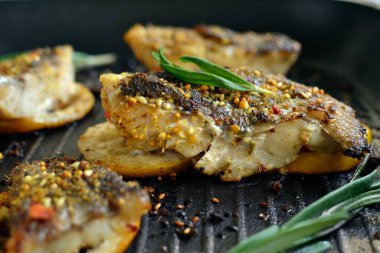 Limonlu ızgara balık, şifalı ot ve biberiye. Izgara tavada kızarmış balık filetosu. Yakın plan..