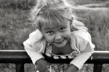 Şirin, sevimli, gülümseyen beyaz beyaz bir çocuğun siyah beyaz portresini kapat. Doğada mutlu bir çocuğun portresi. Mutlu çocukluk kavramı. Bebek kameraya bakıyor..