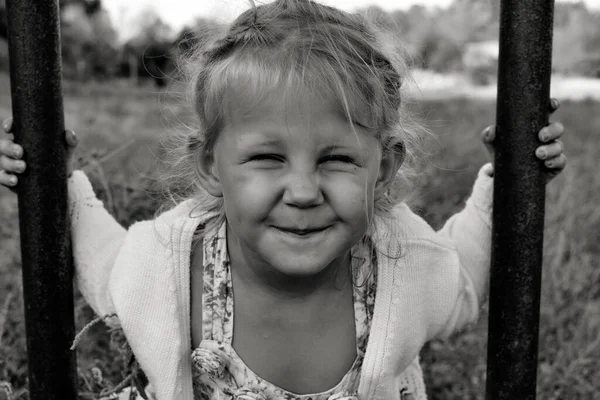 Şirin, sevimli, gülümseyen beyaz beyaz bir çocuğun siyah beyaz portresini kapat. Doğada mutlu bir çocuğun portresi. Mutlu çocukluk kavramı. Bebek kameraya bakıyor..