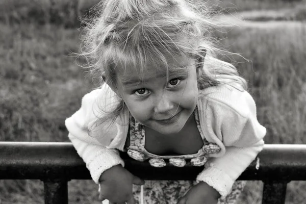 Şirin, sevimli, gülümseyen beyaz beyaz bir çocuğun siyah beyaz portresini kapat. Doğada mutlu bir çocuğun portresi. Mutlu çocukluk kavramı. Bebek kameraya bakıyor..