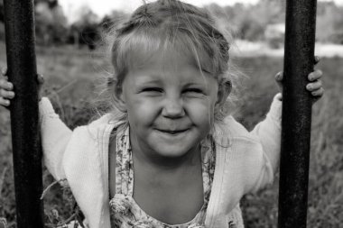 Şirin, sevimli, gülümseyen beyaz beyaz bir çocuğun siyah beyaz portresini kapat. Doğada mutlu bir çocuğun portresi. Mutlu çocukluk kavramı. Bebek kameraya bakıyor..