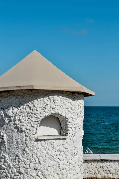Minimalist aesthetics. Minimal detail of architecture against the sky and sea. White clay house, summer photo
