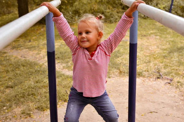 Uma Garotinha Fofa Joga Playground Dia Outono Bebê Pendurado Barras — Fotografia de Stock