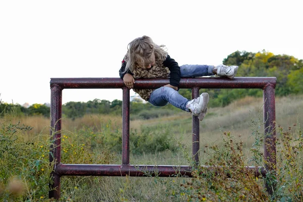 A criança sobe no local. Jogos de secretária perigosos. Segurança das crianças no parque. — Fotografia de Stock