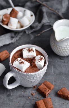 Sıcak çikolata ve lokum. Beyaz bardakta sıcak kakao. Karanlık arka plan. Sonbahar içkisi konsepti. Boşluğu kopyala.