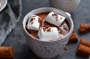 Sıcak çikolata ve lokum. Beyaz bardakta sıcak kakao. Karanlık arka plan. Sonbahar içkisi konsepti. Boşluğu kopyala.